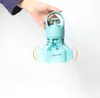 A hand holding a teal-colored dog poop scooper with a blue bag attached. Produktbild-Vorschau