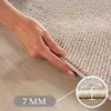 A hand is shown touching the edge of a rug, with a close-up inset showing the rug's thickness. Podgląd zdjęcia produktu