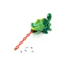 A green toy chameleon with its red tongue extended, ready to catch small toy insects. Anteprima dell’immagine prodotto
