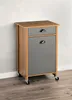 A small cabinet with a drawer and a door, on wheels, placed against a wall. Voir les images du produit