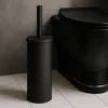 A black toilet brush set and a black toilet in a bathroom. Anteprima dell’immagine prodotto