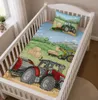 Ambiente-Aufnahme von einem Babybett mit Babybettwäsche Traktor Trecker Bio-Baumwolle 100x135 cm / 40x60 cm. Aus einer schrägen Ansicht dargestellt. Productafbeelding-voorbeeld