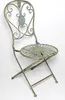 A vintage-style metal folding chair with a sunburst seat and ornate backrest, set against a white background. Náhled obrázku produktu