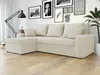 A beige sectional sofa with pillows is shown in a living room setting, with a floor lamp and framed pictures on the wall. Náhled obrázku produktu
