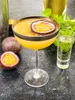 A close-up shot of a passion fruit cocktail with whole and halved passion fruits on the side. Podgląd zdjęcia produktu