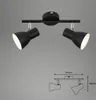 A black metal track light with two adjustable spotlights, shown against a plain gray background. A technical drawing with dimensions is displayed below the product. Produktbild-Vorschau