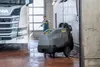 A man is pressure washing a truck in a garage with a Kärcher pressure washer. Produktbild-Vorschau