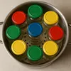 Jars with colorful lids arranged in a steaming pot. Produktbild-Vorschau