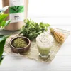 A matcha drink with whipped cream, a bowl of matcha powder, a bundle of mint, and a matcha whisk are arranged on a bamboo mat. Podgląd zdjęcia produktu