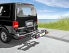 A black van with a bicycle rack attached to the rear, parked by the sea. Produktbild-Vorschau