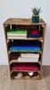 A wooden crate shelf unit with books and a plant. Náhled obrázku produktu