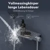 A shower fixture with water spraying from the showerhead, a soap dispenser, and a small container on a shelf. Produktbild-Vorschau