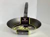 A De Buyer Choc Access frying pan is displayed against a white background. The pan has a black handle and a silver-grey interior and exterior. A yellow and black label is wrapped around the pan, featuring the brand name and product details. Produktbild-Vorschau