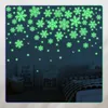 A bedroom scene with glowing snowflake wall stickers on the wall. Podgląd zdjęcia produktu