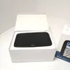 A black TomTom navigation device is shown inside its white packaging. Voir les images du produit