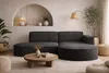 A modern living room with a dark gray sectional sofa, a round wooden coffee table, and decorative elements. Produktbild-Vorschau