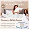 Two women in a bedroom, one holding a pillow and the other wrapped in a blanket, with a bed and bedding visible. Produktbild-Vorschau