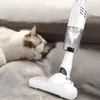 A sleeping cat is on a gray surface next to a white handheld vacuum cleaner. Produktbild-Vorschau