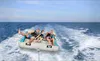 A family is enjoying a ride on an inflatable watercraft towed by a boat on the ocean. Náhled obrázku produktu