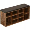 A brown and black shoe cabinet with a cushioned top, showcasing its multiple storage cubbies. Anteprima dell’immagine prodotto