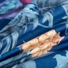 A close-up view of a folded piece of fabric with a floral pattern. Náhled obrázku produktu