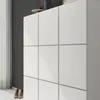 A close-up view of a white cabinet with a grid pattern, showing its doors and side. Produktbild-Vorschau
