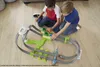 Two young boys playing with a toy car race track on a wooden floor. Produktbild-Vorschau