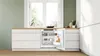 A built-in refrigerator in a modern kitchen, with the door open to reveal its contents. Anteprima dell’immagine prodotto