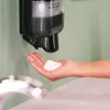 A hand is being washed with foam soap from a dispenser. Anteprima dell’immagine prodotto