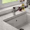 A close-up view of a kitchen sink faucet and countertop. Produktbild-Vorschau