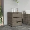 A grey poly rattan cabinet with three drawers sits on a tiled patio next to a plant. Anteprima dell’immagine prodotto