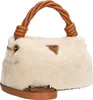 A beige fuzzy handbag with brown leather accents and a twisted handle. Produktbild-Vorschau