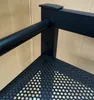 A close-up view of a black metal shelf unit, likely for a washing machine or dryer, with a perforated surface. Produktbild-Vorschau