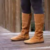 A person wearing brown boots and dark grey leggings standing on a wooden deck. Voir les images du produit