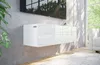 A modern, white, wall-mounted media console is shown mounted on a textured gray wall, with a large television above it. Sunlight streams in from a window to the right, casting shadows on a fluffy white rug and a sofa. Náhled obrázku produktu