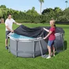 A man and a woman are covering an above-ground swimming pool with a black cover. Produktbild-Vorschau