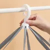 A hand is holding a white drying rack with multiple gray straps hanging down. Produktbild-Vorschau