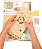 Hands holding a wooden 3D puzzle kit, with packaging and accessories visible. Produktbild-Vorschau