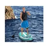 A man is paddleboarding on the ocean near a rocky shore. Produktbild-Vorschau