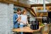 A couple is in a kitchen preparing food, with an air fryer prominently displayed on the counter. Anteprima dell’immagine prodotto