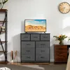 A bedroom or living room scene featuring a dresser with drawers, a television, and decorative items. Voir les images du produit