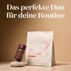 A small brown bottle and a larger white pouch of collagen powder are displayed on a stone. Produktbild-Vorschau
