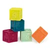 A collection of colorful, soft, textured building blocks with numbers and shapes on them, arranged in a playful stack and scattered. Podgląd zdjęcia produktu