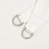 A close-up view of the corner of a white sun sail, showing the reinforced fabric and metal D-rings used for attachment. Voir les images du produit
