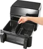 A hand is shown inserting a divider into a dual-chamber air fryer basket. Produktbild-Vorschau