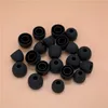 A pile of black silicone earbud tips on a light peach background. Produktbild-Vorschau