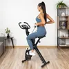 A woman is exercising on a stationary bike in a room. Náhľad obrázku produktu