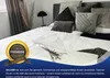 A bed with multiple pillows and a white duvet, decorated with dried flowers. Produktbild-Vorschau