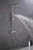 A modern shower set with a rain shower head and a hand shower, mounted on a gray tiled wall. Water is spraying from the shower head. Produktbild-Vorschau