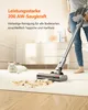 A person is using a cordless vacuum cleaner to clean up a mess on a carpet, with a white cat lying nearby. Produktbild-Vorschau